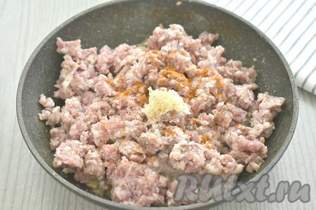 Затем к луку и шампиньонам добавляем мясной фарш, по вкусу солим, добавляем пропущенный через пресс чеснок и специи (я всыпала паприку и чёрный молотый перец), перемешиваем и обжариваем 6-7 минут, иногда помешивая. Убираем с огня и даём остыть.