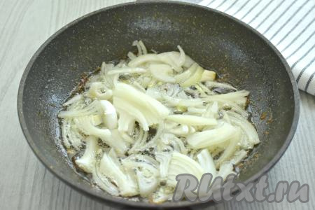 Очищенную луковицу нарезаем на полукольца (или четверть кольца), выкладываем в сковороду, в которой обжаривалась курица. На среднем огне обжариваем лук, иногда помешивая, до мягкости (примерно 3 минуты).