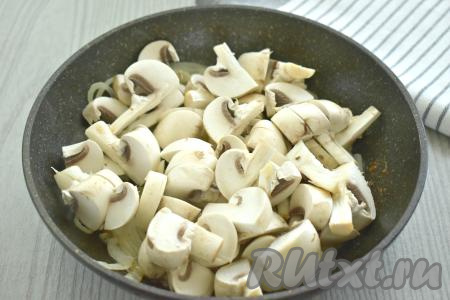 Шампиньоны моем, немного обсушиваем, нарезаем на средние кусочки, добавляем к обжаренному луку, перемешиваем и обжариваем грибы 6-7 минут, периодически перемешивая. Затем убираем с огня и даём слегка остыть.