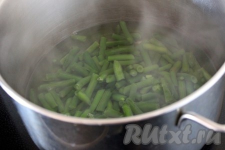 Посолить воду, довести до кипения, убавить огонь до среднего и варить фасоль стручковую 5 минут.