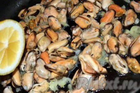 Репчатый лук нашинковать, немного обжарить на оливковом масле, добавить мидии, пожарить всё вместе около пяти минут, добавить лимонную цедру и полить лимонным соком.