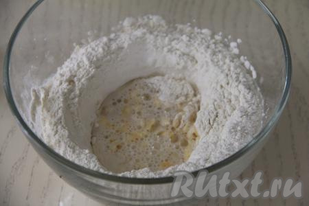 Немного перемешать вилкой, влить холодную воду и растительное масло, перемешивать вначале вилкой, а затем хорошо вымесить тесто руками.