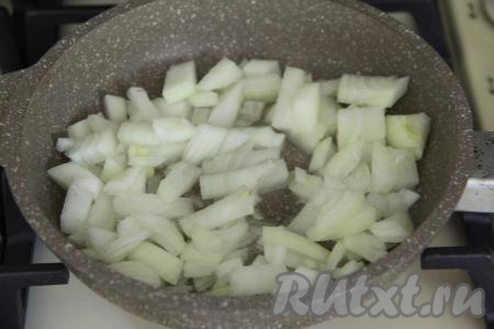 В сковороду влить растительное масло, поставить на огонь. В разогревшееся масло выложить лук, нарезанный на средние кубики, и обжаривать его на среднем огне минут 5 (до прозрачности), иногда помешивая.