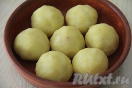 Аналогично сформировать и выложить в форму все 7 шариков. Яичный желток в небольшой ёмкости взбить вилкой до однородности. Смазать картофельные шарики яичным желтком.&nbsp;