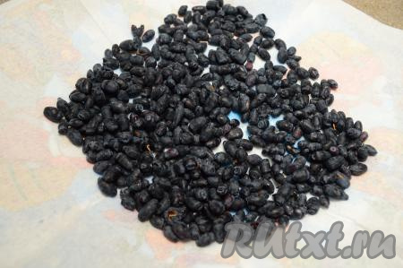 Заранее достать из холодильника сливочное масло, чтобы оно успело согреться до комнатной температуры. Первым делом следует перебрать ягоды жимолости, удалив мусор и листики. Промыть ягоды и выложить их на бумажные салфетки, дать обсохнуть. Этот пирог можно готовить и с замороженной жимолостью, если на ягодах нет большого количества льда, тогда их можно не размораживать. Если же ягоды покрыты большим количеством наледи, тогда слегка разморозьте их и лишнюю воду слейте.