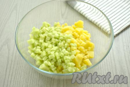 Порядок нарезания продуктов для окрошки особого значения не имеет, предлагаю начать с картошки и свежего огурца. Нарезаем варёный картофель на маленькие кубики, перекладываем в объёмную миску. С огурца срезаем кожуру. Нарезаем огурчики на кубики такого же размера, как нарезали картошку, добавляем в миску.