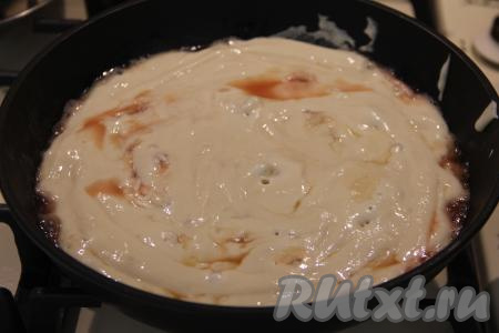 Выложить тесто поверх персиков, равномерно распределяя его столовой ложкой.