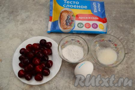 Подготовить продукты для приготовления слоек с черешней. Слоёное тесто можно взять дрожжевое или бездрожжевое, в этом рецепте это неважно. Ягоды черешни можно использовать как свежие, так и замороженные. Свежую черешню нужно вымыть, дать ей немного обсохнуть. Если черешня заморожена, тогда её нужно слегка разморозить, лишнюю воду слить. Слоёное тесто заранее разморозить. Я обычно вечером перекладываю пачку слоёного теста из морозилки в холодильник, а утром в холодильнике уже будет размороженное тесто. Можно, конечно, разморозить тесто и при комнатной температуре.