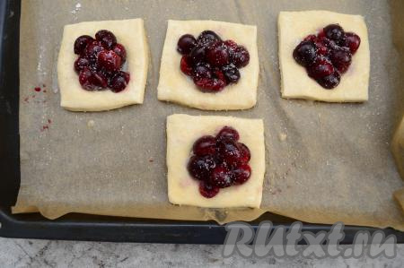Яйцо взболтать вилкой. Смазать яйцом заготовки из слоёного теста. Ягоды присыпать сахаром. Я взяла сладкую черешню, мне хватило 0,5 чайной ложки сахара на каждую слойку. Если у вас несладкая черешня, тогда присыпьте ягоды 1 чайной ложкой сахара.