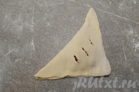 Накрыть начинку стороной с надрезами. Должен получиться аккуратный пирожок треугольной формы.