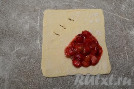 Ближе к противоположенному углу, не доходя до краёв 1-1,5 сантиметра, выложить примерно 1,5 столовых ложки клубничной начинки.