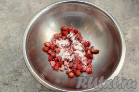 Нарезанную клубнику выложить в миску, добавить крахмал и сахар. Крахмал будет желировать начинку из клубники в процессе выпечки, поэтому, даже если вдруг слоёное тесто где-то разойдётся в духовке, начинка не будет сильно вытекать из пирожков.