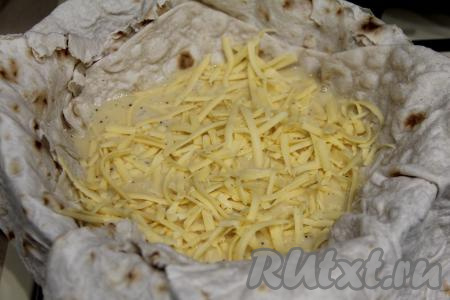 Сверху на яично-молочную смесь выложить натёртый сыр.