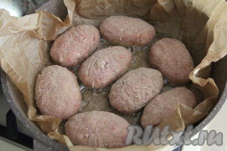 Котлеты можно, как обычно, выложить на сковороду с хорошо разогревшимся растительным маслом. Я решила пожарить котлеты на сковороде, застеленной пергаментом для выпечки. Для этого в сковороду выложить пергамент, добавить немного растительного масла. Поставить сковороду на огонь и выложить котлеты на пергамент.
