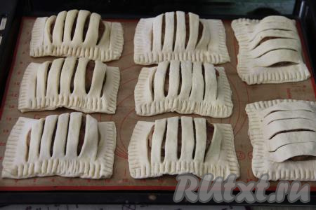 Аналогично сформировать все заготовки котлет в слоёном тесте. Переложить заготовки на противень, застеленный ковриком (или пергаментом) для выпечки. Если у вас дрожжевое слоёное тесто, тогда нужно оставить котлеты в тесте для расстойки минут на 20. Слойки из бездрожжевого теста можно на расстойку не оставлять.