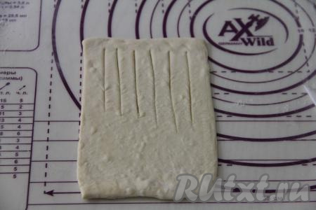 Каждый квадратик теста на припылённой мукой поверхности раскатать в длинный прямоугольник толщиной 2-3 миллиметра. Сделать надрезы острым ножом на одной узкой&nbsp; половине прямоугольника, как на фото.