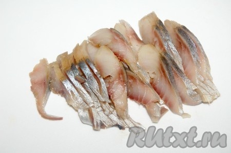 Взять филе соленой сельди, нарезать  на тонкие кусочки и добавить к картофелю с фасолью.