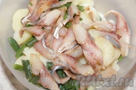 Взять филе соленой сельди, нарезать  на тонкие кусочки и добавить к картофелю с фасолью.