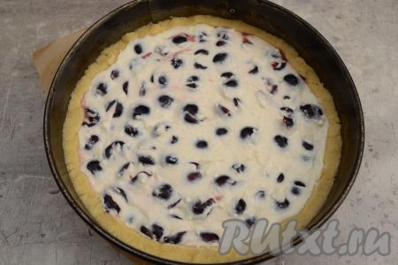 Равномерно распределить творожную заливку поверх черешни. Если бортики из теста получились значительно выше, чем начинка, их можно немного подвернуть на начинку. Поставить форму в духовку, заранее разогретую до 180 градусов, выпекать песочный пирог с черешней и творогом минут 45.