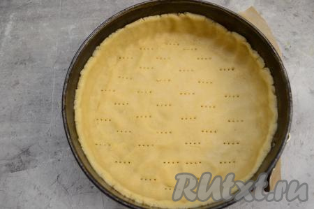 Дно разъёмной формы для выпечки (я взяла диаметром 23 сантиметра) застелить пергаментом. Бока формы смазать растительным (или сливочным) маслом. По дну формы распределить песочное тесто, сформировать невысокий бортик. Тесто на дне формы наколоть вилкой, чтобы оно равномерно поднималось во время выпечки.&nbsp;