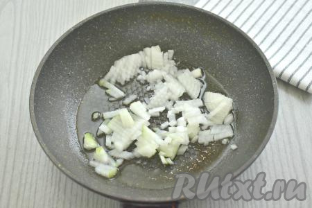 Покупное слоёное тесто для этой выпечки можно взять как дрожжевое, так и бездрожжевое. Достаём слоёное тесто и оставляем его размораживаться при комнатной температуре. Пока тесто размораживается, можно заняться грибной начинкой для пирога. Свежие шампиньоны моем (если вы решили готовить пирог с лесными грибами, тогда предварительно отварите их в течение 25-30 минут с момента закипания воды, а затем дайте стечь лишней воде). Прогреваем растительное масло в сковороде, после этого выкладываем очищенный и мелко нарезанный лук. Обжариваем лук на среднем огне, периодически перемешивая, 3-4 минуты (до прозрачности лука).