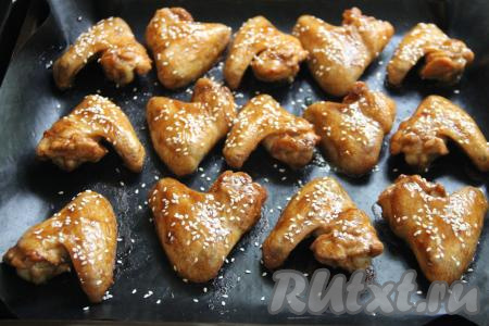 Куриные крылышки запекать в разогретой духовке при температуре 180 градусов 30-35 минут. Затем достать противень и с помощью кисти смазать крылья сверху соусом "Терияки". Поставить снова в духовку на 5 минут. Затем смазать крылья второй раз соусом "Терияки", присыпать кунжутом и снова поставить на 5 минут в духовку.