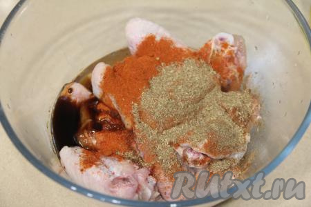 Подготовленные куриные крылышки выложить в глубокую миску, добавить соль и специи (я добавила 1 чайную ложку карри и 1 чайную ложку паприки), влить растительное масло, соевый соус и 3 столовых ложки соуса "Терияки".