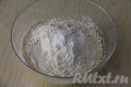 В получившуюся масляно-яичную смесь всыпать разрыхлитель и половину просеянной муки, перемешать.