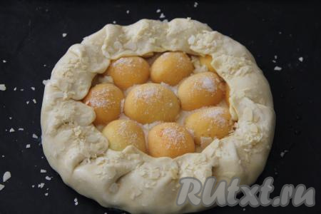 Присыпать абрикосы 2 столовыми ложками сахара. Завернуть тесто по краю и хорошо защипать, формируя открытый пирог, как на фото. Слегка смазать тесто водой и, по желанию, присыпать сахаром или лепестками миндаля.