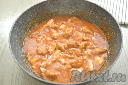 После закипания, уменьшив огонь до минимума, тушим мясо курицы в соусе 10 минут, иногда перемешиваем.