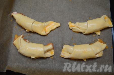 Каждую заготовку смазать взбитым яйцом, а затем отправить выпекаться в разогретую до 200 градусов духовку на 20-25 минут.