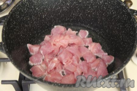 В глубокой сковороде (или в кастрюлю с толстым дном) разогреть растительное масло, после этого выложить филе индейки, нарезанное на кубики с размером стороны примерно 2 сантиметра.