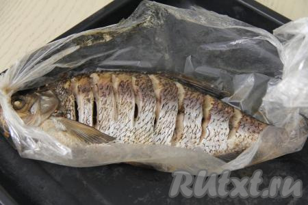 Рукав с рыбой выложить на противень и поставить в разогретую духовку. Запекать при температуре 200 градусов 40 минут. Затем достать противень из духовки, аккуратно разрезать рукав и переложить леща на блюдо для подачи.