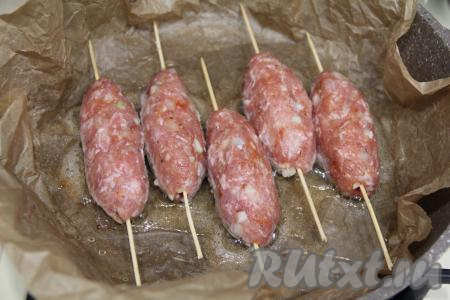 В сковороду влить растительное масло и разогреть. Я сначала застелила сковороду пергаментом для выпечки, таким образом масло не будет брызгаться во время жарки, а затем уже влила масло и разогрела его. Выложить люля-кебабы на сковороду в разогревшееся масло.
