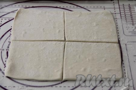 У меня слоёное тесто в двух пластах. Каждый пласт теста раскатать на припылённой мукой поверхности в квадрат толщиной примерно 3 миллиметра и разрезать на 4 квадрата. То есть из двух пластов теста мы будем формировать 8 турноверов.