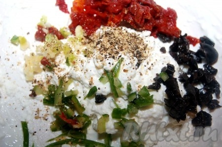 Фету размять вилкой, добавить сметану (или йогурт), мелко нарезанные вяленые помидоры, оливки, кожуру огурца, чеснок. Перец горошком размолоть в ступке и добавить к полученной массе. Не забыть выжать сок из лимона.