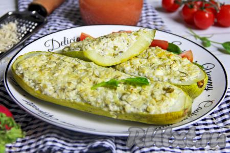 Готовые кабачки, фаршированные творогом, зеленью и чесноком, достать из духовки, переложить на тарелку и подать сочное, нежное, вкусное блюдо в горячем виде к столу, дополнив, по желанию, сметанным соусом.