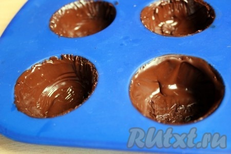 Затем достать силиконовые формочки и нанести ещё один слой шоколада, чтобы корзинки получились прочными и не сломались при извлечении. Снова поставить в морозилку и дать шоколаду застыть.
