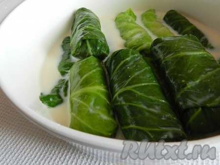 Голубцы сложить в кастрюлю, залить молоком, довести до кипения, уменьшить огонь, накрыть крышкой и тушить, примерно, 20 минут.
