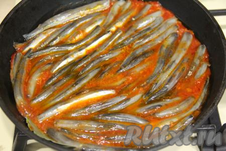 На овощную подушку, покрытую томатным соусом, выложить мойву брюшком вниз.&nbsp;