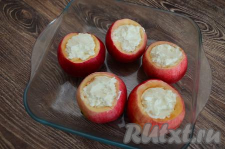Аналогично вырезать чашечки из остальных яблок. Поместить эти чашечки в форму для запекания, а затем с помощью чайной ложки наполнить яблоки творожной массой.