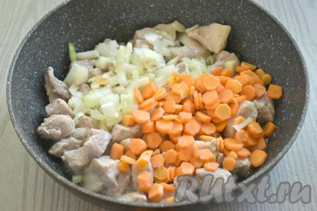 К обжаренному мясу выкладываем мелко нарезанный лук и нарезанную на достаточно тонкие кружочки (или брусочки) морковку.