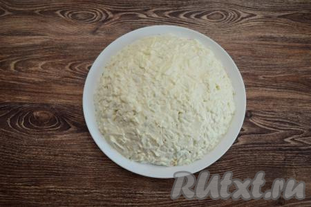 Поверх белков нанести майонез, разровнять его при помощи лопатки, придавая салату законченную аккуратную форму.