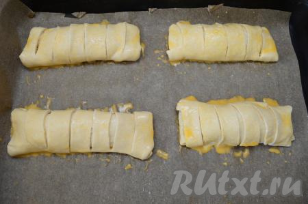 В небольшой ёмкости яйцо взбить венчиком (или вилкой) до однородности. Смазать слойки с яблоками взбитым яйцом.