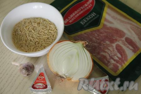 Подготовить продукты для приготовления пасты "Орзо" с беконом. Лук и чеснок почистить. В кастрюле вскипятить достаточно большое количество воды, посолить, всыпать пасту "Орзо", перемешать, дать закипеть и варить на небольшом огне до готовности (как правило, орзо варится 8-10 минут, но точное время варки смотрите на упаковке макаронных изделий, которые вы готовите).&nbsp;