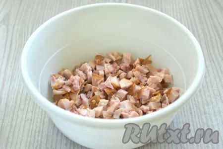 Для этой выпечки подойдёт как дрожжевое, так и бездрожжевое покупное слоёное тесто. Достаём слоёное тесто из морозилки и оставляем его размораживаться при комнатной температуре. Копчёное куриное мясо можно взять с грудки курицы, бёдер или голеней. Нарезаем копчёное мясо курицы на маленькие кубики и перекладываем в миску.