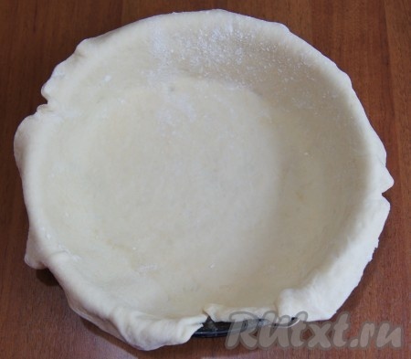 От теста отрезаем кусочек для верхушки, из оставшегося теста раскатываем круглый пласт. Он должен быть больше Вашей формы для выпечки. Форму смазываем маслом и присыпаем мукой. Выкладываем форму тестом.