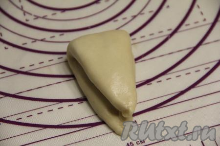 Свернуть булочку вдвое. Получится вот такая треугольная булочка с начинкой. Аналогично из дрожжевого теста сформировать оставшиеся 7 заготовок булочек со сливами.