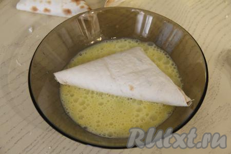 Каждый конвертик из лаваша обмакнуть в яичную массу с двух сторон. Покрывать яичной смесью нужно столько конвертиков, сколько сможет поместиться на сковороду за один раз.