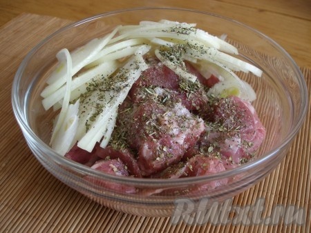 Мясо индейки нарезать крупными кусочками, очищенную луковицу нарезать полукольцами, выложить в миску, посыпать солью, перцем, сухими итальянскими травами.
